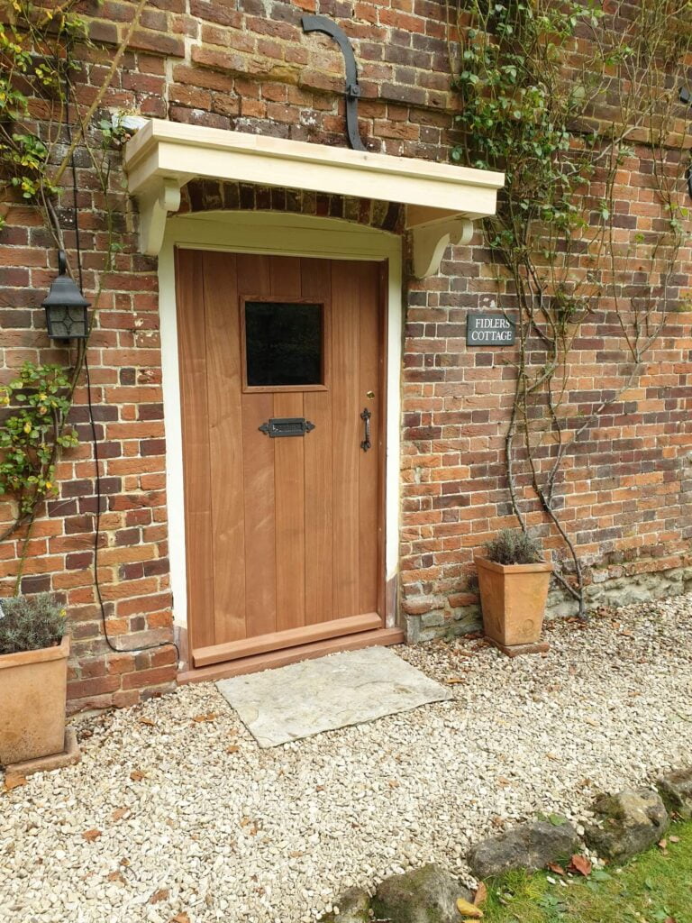 A brown wood front door. For page doors and windows fitted by gray & amor in devizes, marlborough, wiltshire